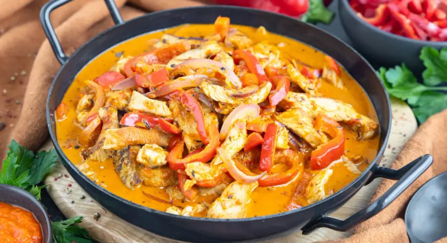 Ein einfaches Putengeschnetzeltes-Rezept mit Paprika und Zwiebeln in cremiger Sauce, serviert in einer Pfanne.