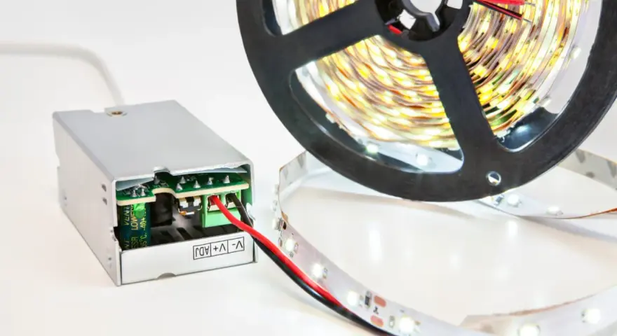 Zasilacz do taśmy LED 5m. Zasilacz impulsowy z zielonym złączem i czerwoną diodą. Rolka taśmy LED z białymi diodami.