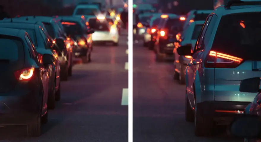 Traffico serale con luci sfocate, come vede le luci un miope. Le auto ferme creano un effetto di aloni luminosi.