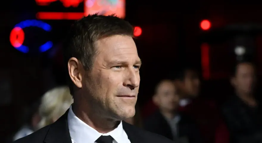 Aaron Eckhart, protagonista di molti film, in primo piano con uno sguardo intenso.