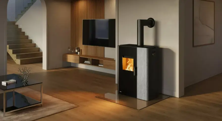 Estufa mixta pellets y leña canalizable, con fuego encendido, en un salón moderno con escaleras y TV.
