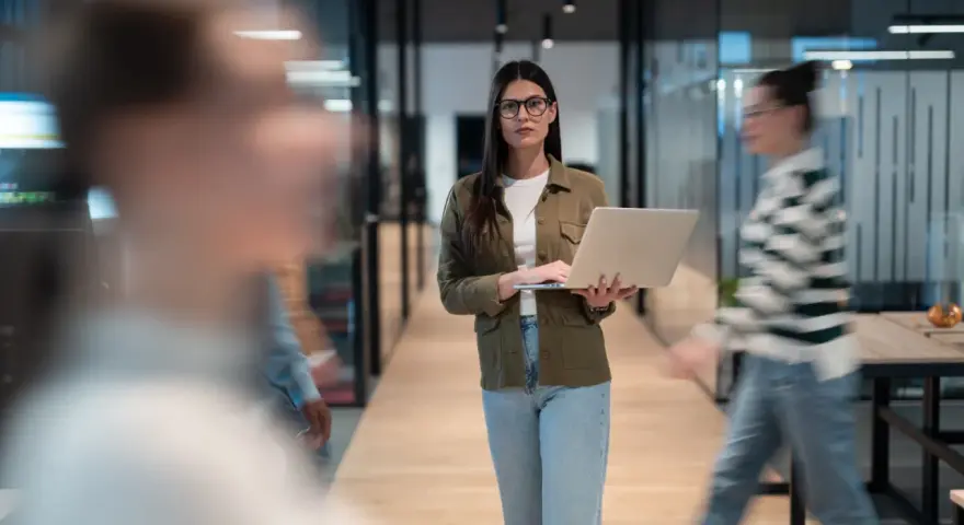 Femme avec un ordinateur portable dans un bureau moderne, préparant une annonce légale changement de gérant.