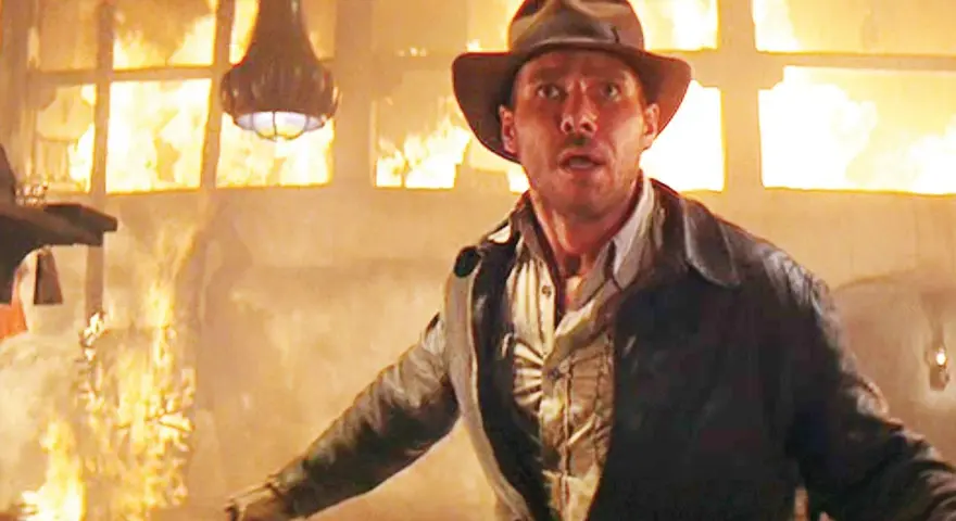 Indiana Jones in un edificio in fiamme, un momento iconico di film azione e avventura.