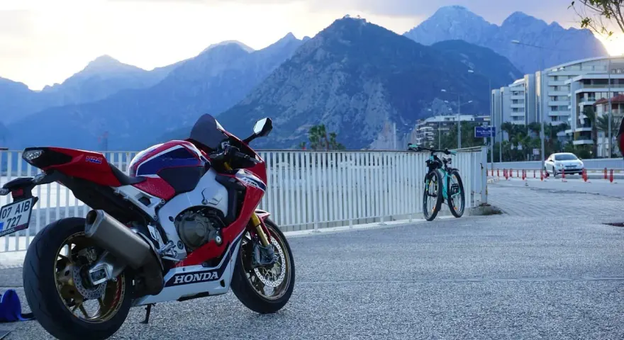 Sportowy motocykl Honda i dwa rowery na tle gór. Wyobraź sobie podróż po **tajlandii północnej** na tym sprzęcie.