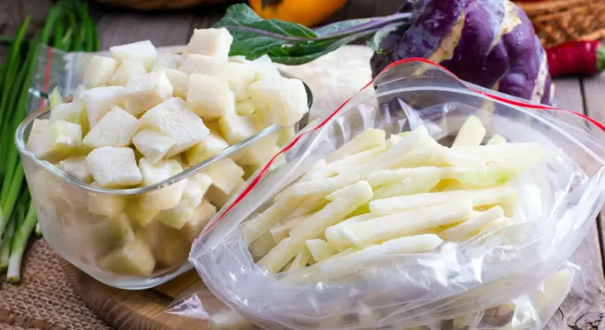 Gefrorene Kohlrabi-Würfel und -Stifte in Gefrierbeuteln und einer Schüssel. Perfekt zum Kohlrabi einfrieren für später.