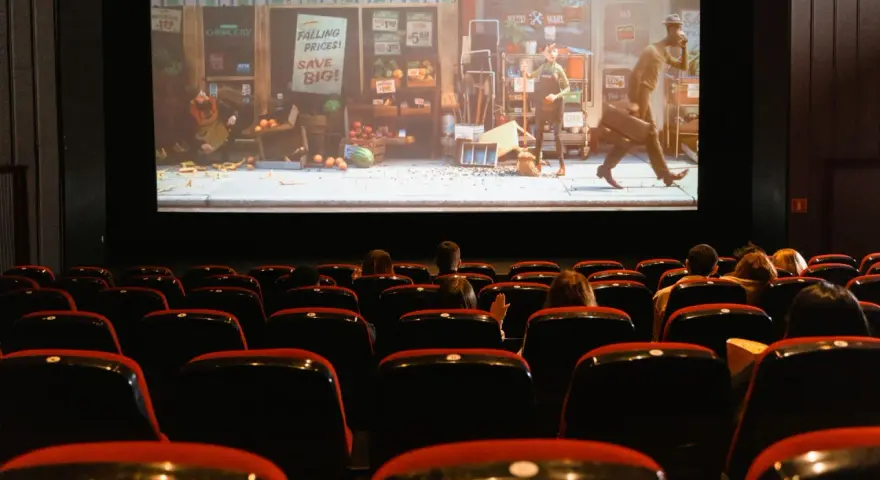 Una sala de cine con público observando una película animada. Esto es que es el cine: una experiencia compartida de historias en pantalla grande.