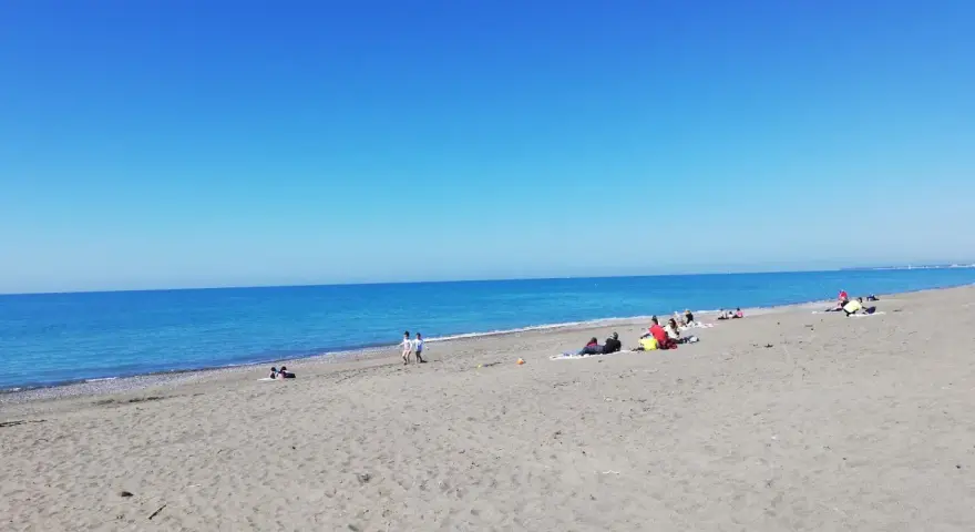 Słoneczny dzień na plaży w Marina di Bibbona. Ludzie odpoczywają na piasku, a morze lśni w słońcu.
