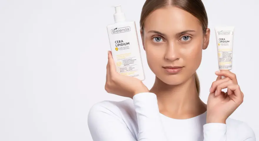 Kobieta prezentuje emulsję i krem Bielenda Cera Lipidum. Produkty z linii linoderm odbudowują barierę lipidową skóry.