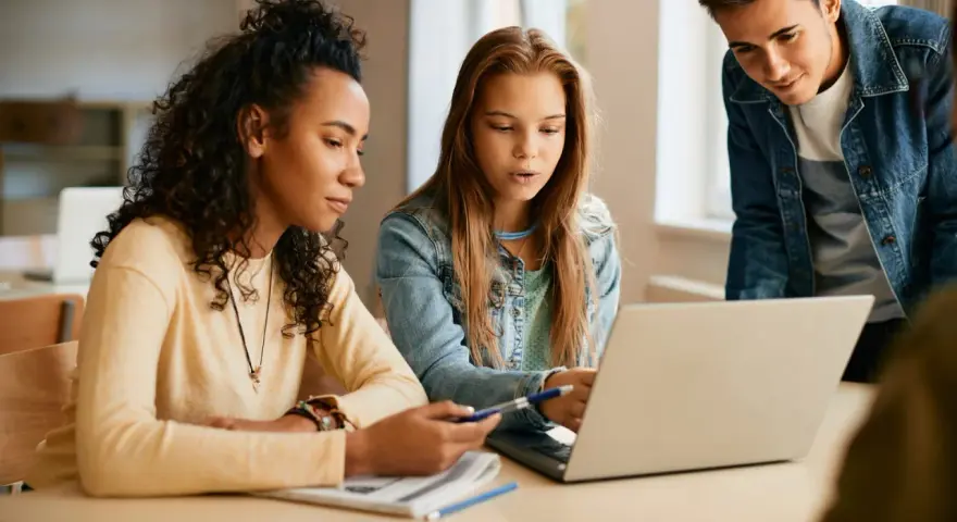 Uczniowie technikum artystycznego w Warszawie pracują nad projektem na laptopie.