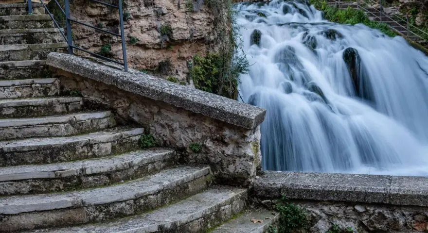Escaleras de piedra desgastada conducen a las impresionantes trillo cascadas, con agua blanca cayendo en cascada sobre rocas cubiertas de musgo.