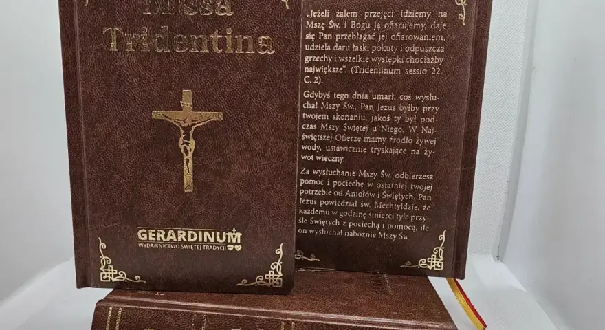 Brązowe księgi z napisem "Missa Tridentina" i złotym krzyżem. Jedna otwarta, z tekstem o Mszy Świętej.