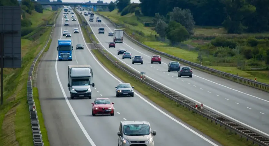 Ruch na autostradzie, gdzie samochody jadą różnymi pasami. Pytanie, czy na autostradzie można wyprzedzać z prawej strony, jest kluczowe dla bezpieczeństwa.