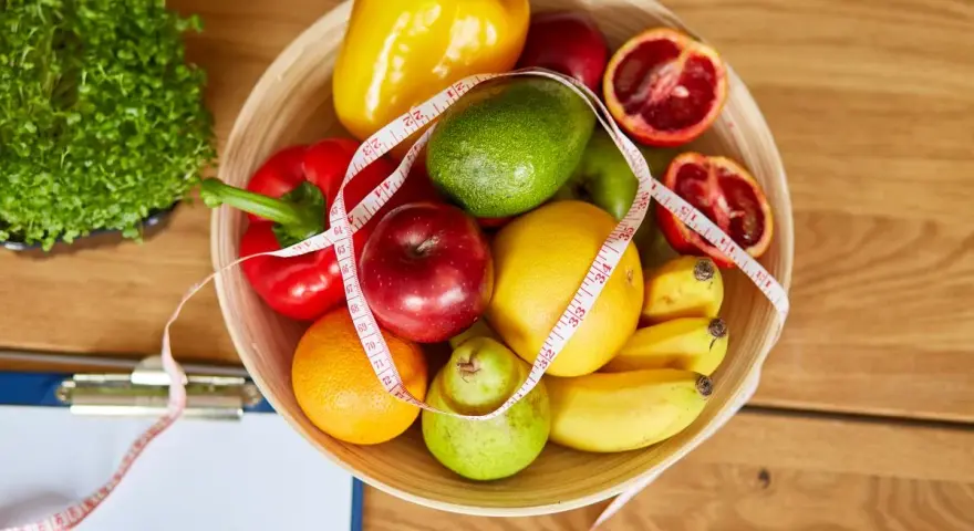 Miska pełna owoców i warzyw, miarka krawiecka. Idealne składniki na zdrowy dieta 500 kcal jadłospis na tydzień.