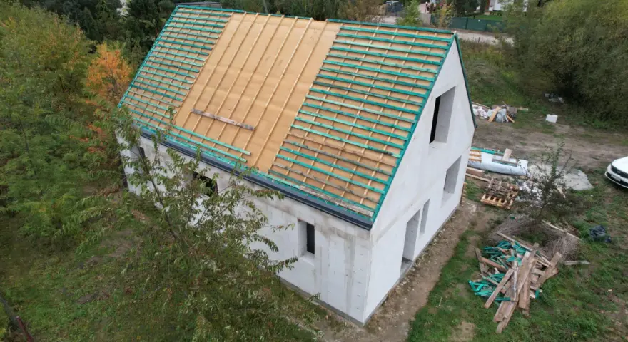 Budowa projektu domu 30m2 w trakcie. Widoczna konstrukcja dachu z łatami.