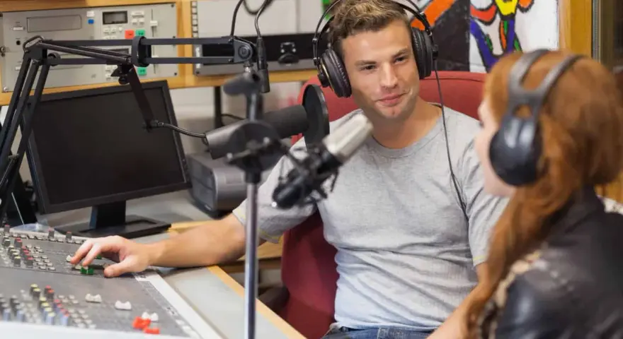 Mann und Frau mit Kopfhörern im Tonstudio, ein Beispiel für spannende Jobs in der Musikindustrie.
