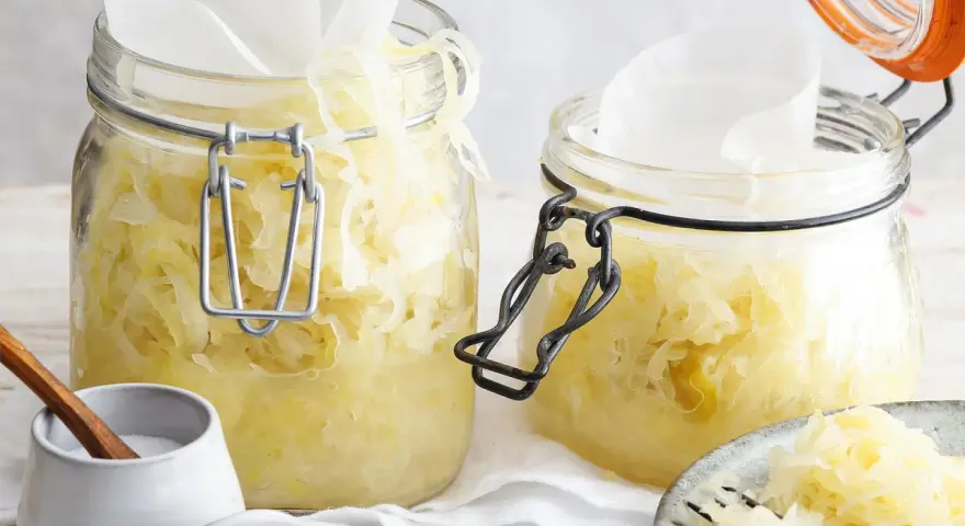 Zwei Gläser mit hausgemachtem Sauerkraut, bereit für die Fermentation. Ein einfaches Sauerkraut Rezept für gesunde Beilagen.