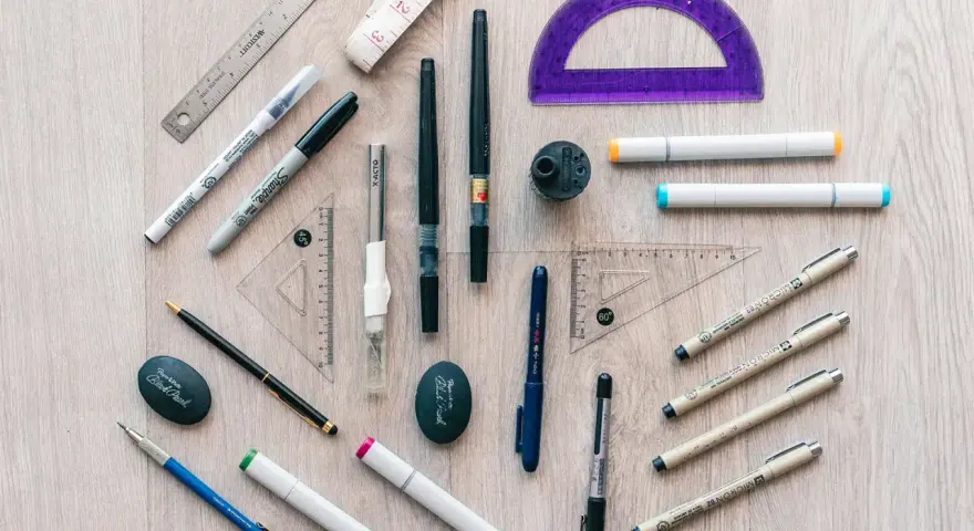 Herramientas de dibujo: reglas, escuadras, transportador, marcadores, bolígrafos y un sacapuntas. ¡Todo listo para crear!