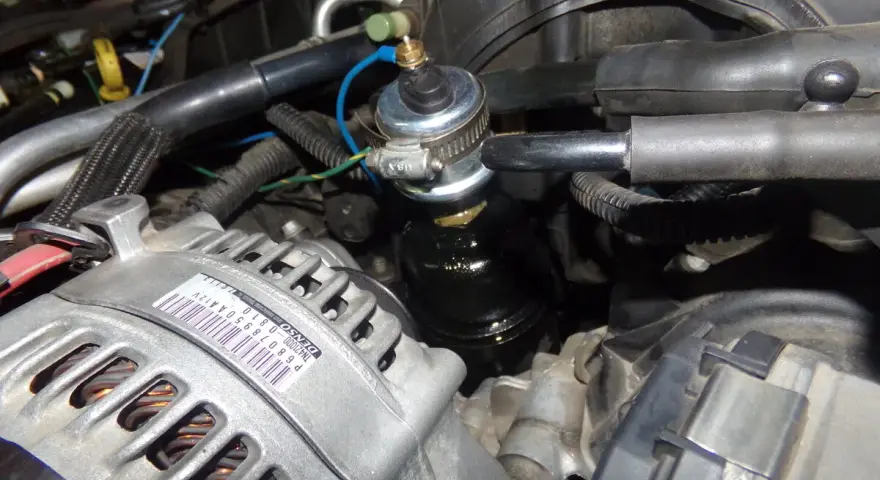 Close-up of a p0520 Dodge engine bay, showing the alternator and a fuel pressure regulator.