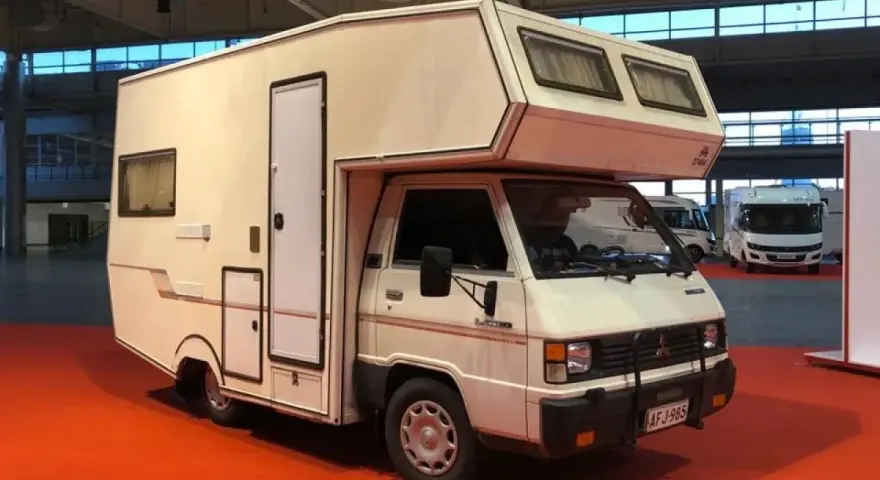 Biały kamper Mitsubishi L300 z zabudową mieszkalną, gotowy na przygody.