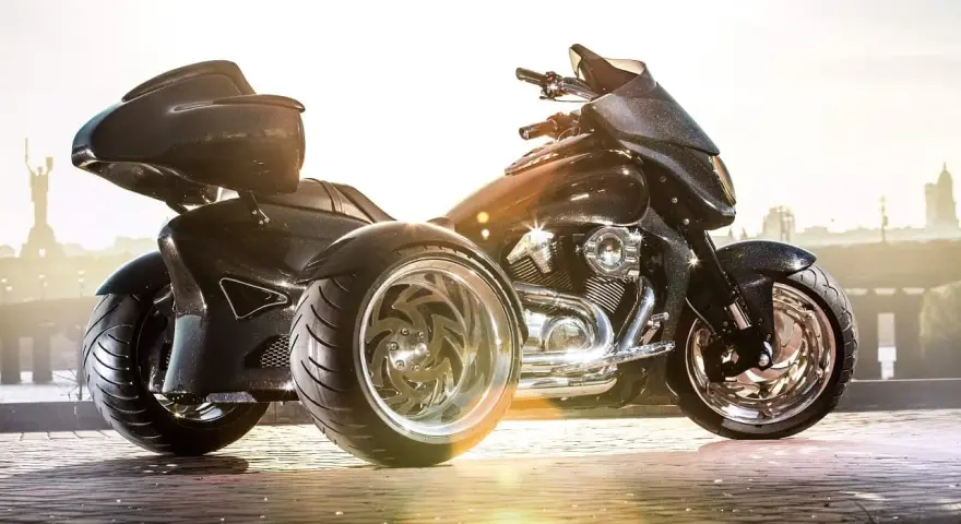 Czarny, lśniący motocykl trzykołowy z chromowanymi felgami, gotowy do podróży.