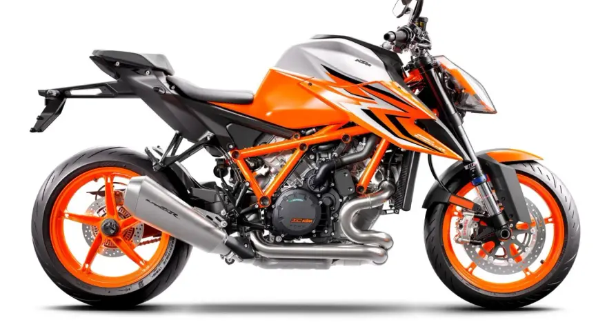 Pomarańczowo-biały motocykl KTM 1290 Super Duke R z agresywnymi grafikami i pomarańczowymi felgami.