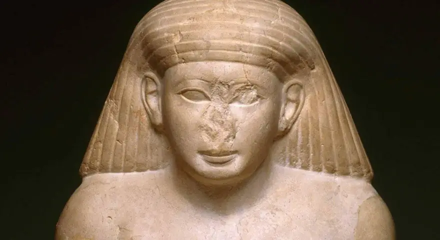 Buste en pierre d'une statue antique, le nez égyptien est abîmé, mais le regard est toujours intense.