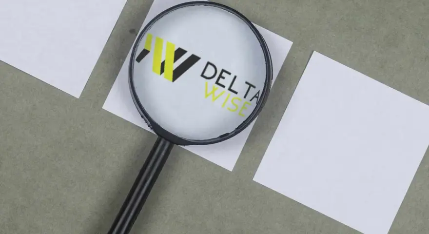 Lupa powiększa logo DELTA WISE, symbolizując dokładność w windykacji.