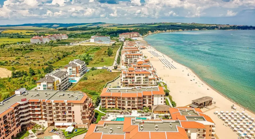 Widok z lotu ptaka na kurort nad Morzem Czarnym w Bułgarii. Zastanawiasz się, ile się leci do Bułgarii? Tuż obok plaży z leżakami i parasolami, rozciągają się hotele i apartamenty.