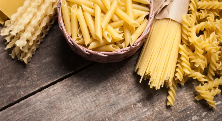 Różne rodzaje makaronu: penne, spaghetti, fusilli i faliste tagliatelle. Wybór między makaronem grahan a durum zależy od preferencji.