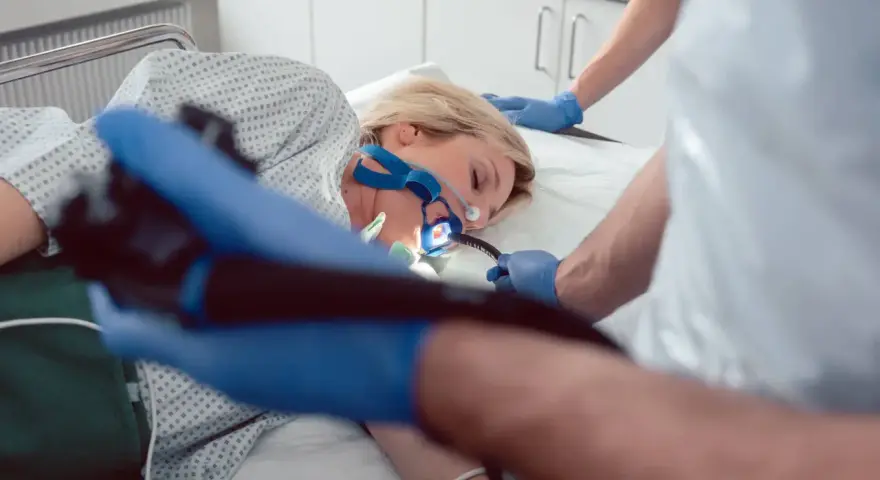 Pacjentka poddana endoskopii w celu diagnozy eozynofilowego zapalenia przełyku. Lekarz wprowadza endoskop.
