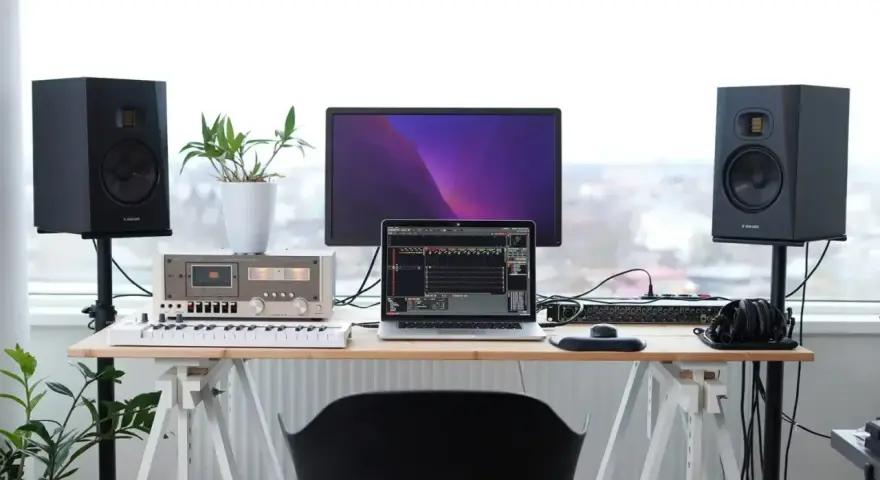 Studio z monitorami Adam Audio T7V, laptopem, klawiaturą i mikserem. Idealne miejsce do tworzenia muzyki.