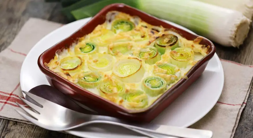 Puerros al horno gratinados, tiernos y dorados, listos para disfrutar.