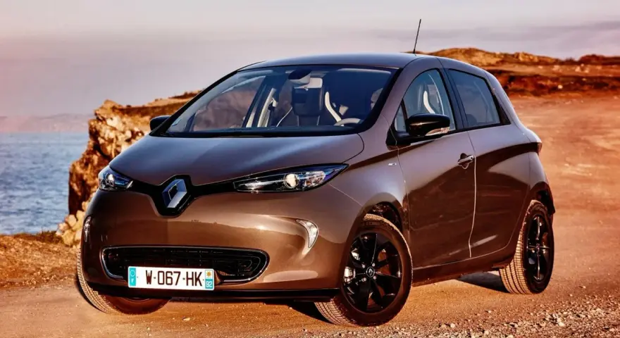 Brązowy Renault Zoe na tle morza i klifów. Poznaj jego renault zoe dane techniczne.