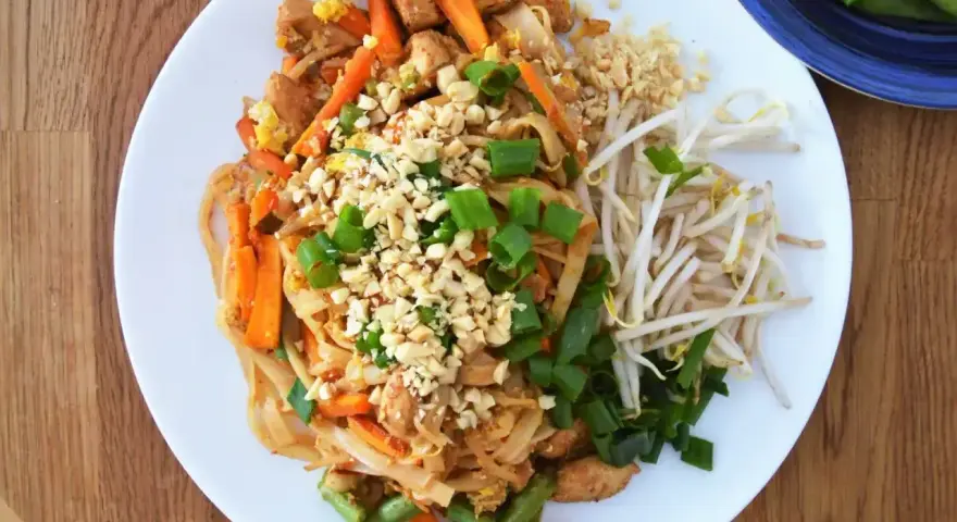 Pyszny Pad Thai z kurczakiem, warzywami i orzeszkami ziemnymi, polany aromatycznym sosem do Pad Thai.