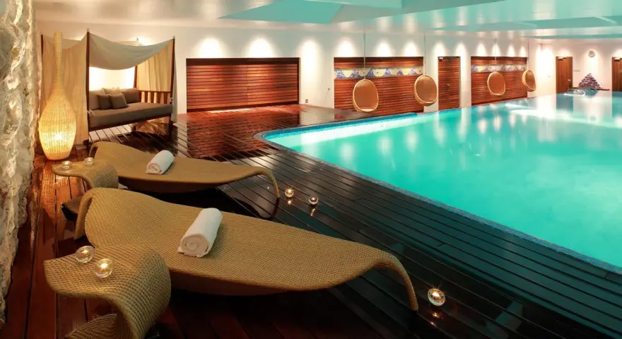 Rilassati in questa spa: piscina turchese, lettini comodi, candele e un'atmosfera di pace. Ecco cosa si fa in una spa per rigenerarsi.
