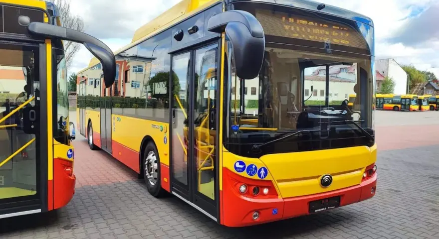 Nowe autobusy Yutong w barwach żółto-czerwonych stoją na placu.