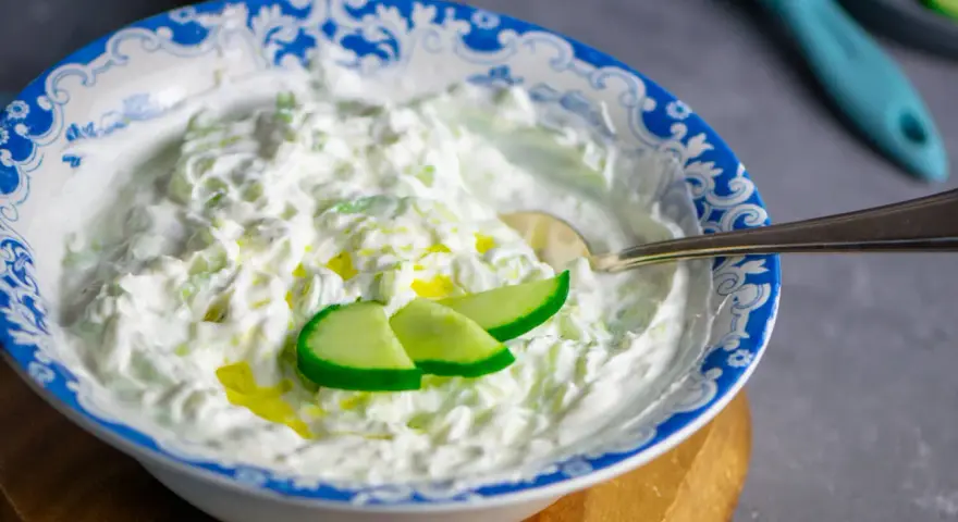 Cremiger Tzatziki-Dip mit Gurkenstücken und Olivenöl, perfekt für ein einfaches Tzatziki Rezept.