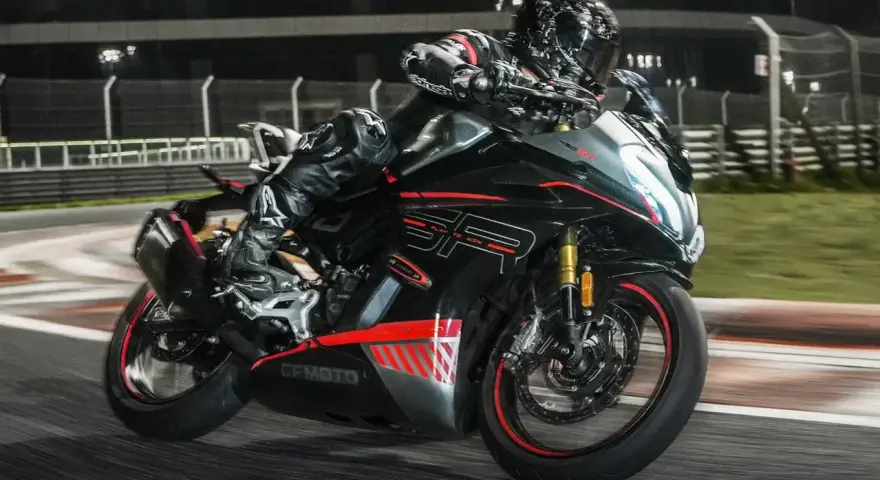 Un pilota in tuta nera sfreccia in pista con la CF Moto 450 SR, puntando alla velocità massima.