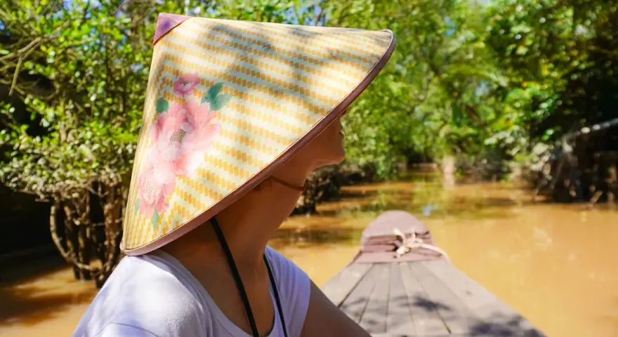 Giro in barca tra i canali del Vietnam, con un cappello tradizionale. Un'esperienza da non perdere tra le cose da fare a Vietnam.