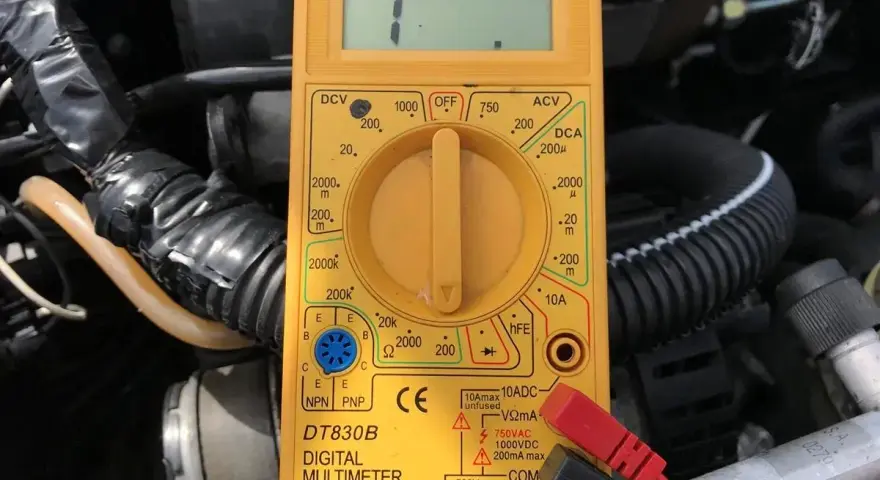 Żółty multimetr pokazuje "1", co może pomóc jak sprawdzić który to kabel w samochodzie.