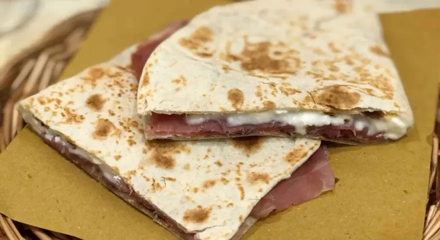 Piadine ripiegate con prosciutto e formaggio cremoso, semplici ingredienti piadina che creano un sapore delizioso.
