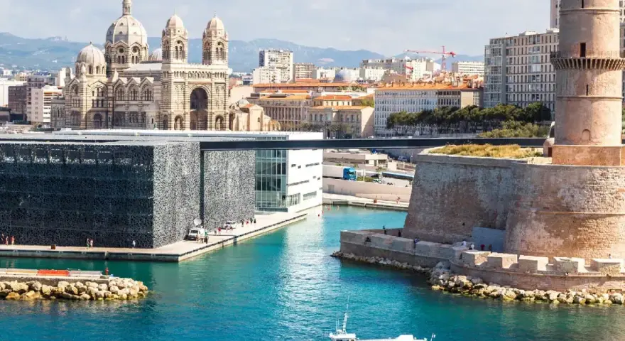Widok na port w Marsylii z katedrą, nowoczesnym budynkiem MuCEM i wieżą Saint-Jean.