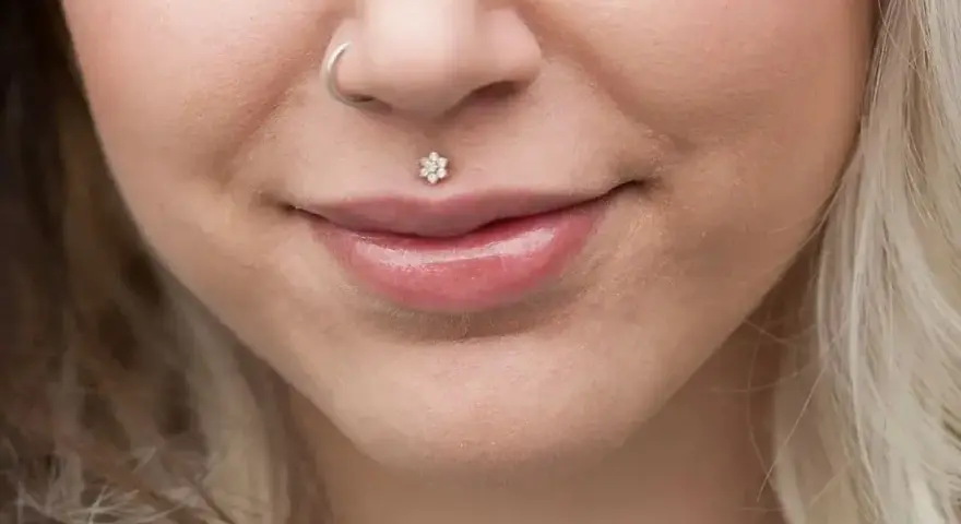 Delikatny piercing ust w kształcie kwiatka, ozdoba twarzy. Dowiedz się, co to piercing i jak podkreśla urodę.
