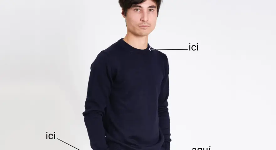 Un homme porte un pull bleu marine. Le tissu pul endroit envers est visible sur le bord du pull.
