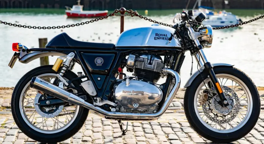 Błyszczący, chromowany rozrząd królewski Royal Enfield Continental GT 650 na tle portu.