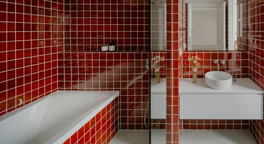 Salle de bain aux carreaux rouges vifs. La question "faut il carreler toute la salle de bain" se pose face à cette audace. Baignoire, lavabo et douche sont intégrés.