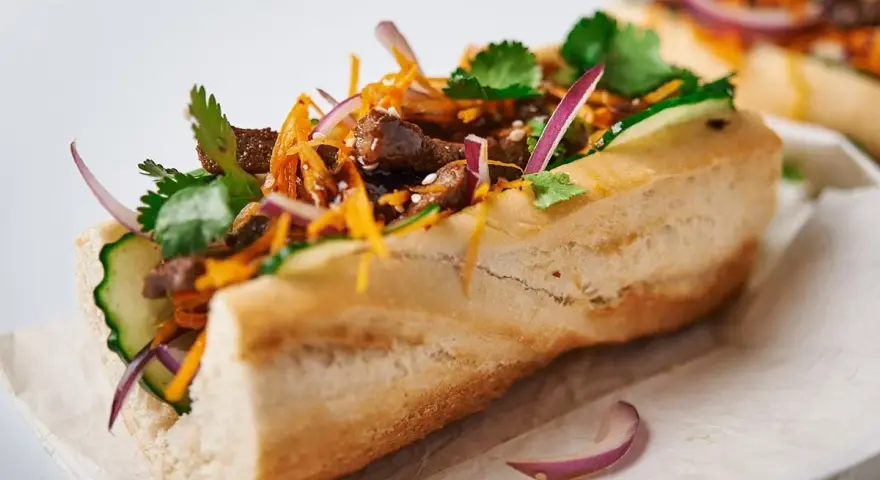 Pyszny banh mi przepis: bagietka z wołowiną, ogórkiem, marchewką, czerwoną cebulą i kolendrą.
