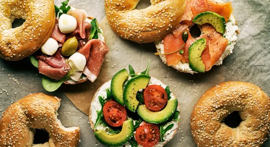 Pyszne bajgle z łososiem, awokado, pomidorami, szynką i mozzarellą – idealne co zamiast chleba na śniadanie czy lunch.