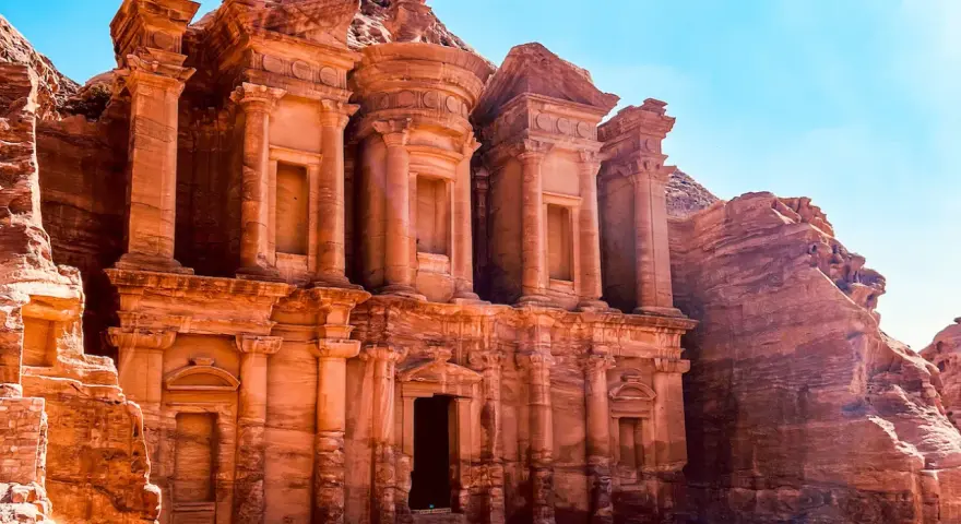 Le Monastère d'Ad-Deir, un trésor de Petra en Jordanie, se dresse majestueusement sculpté dans la roche ocre sous un ciel bleu éclatant.