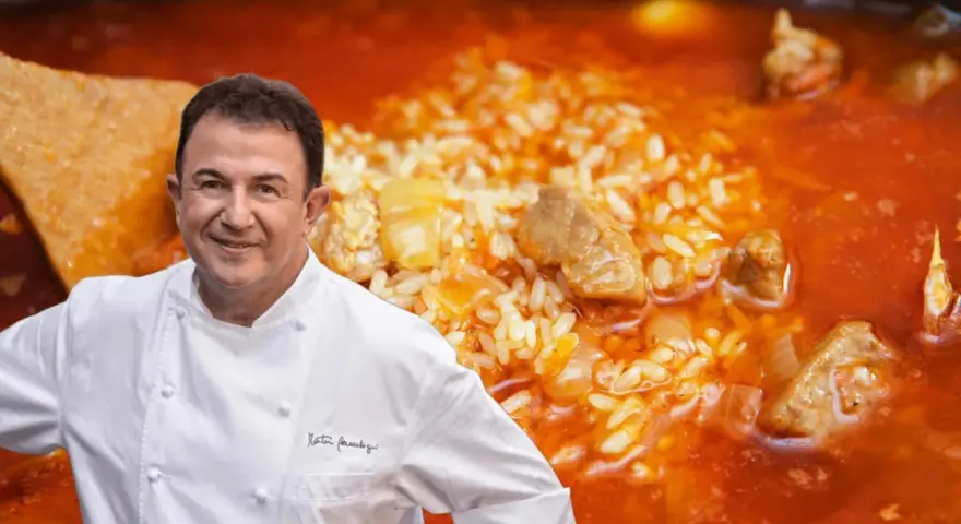 Chef Dani García sonríe junto a un plato de arroz meloso con trozos de atún y carne.